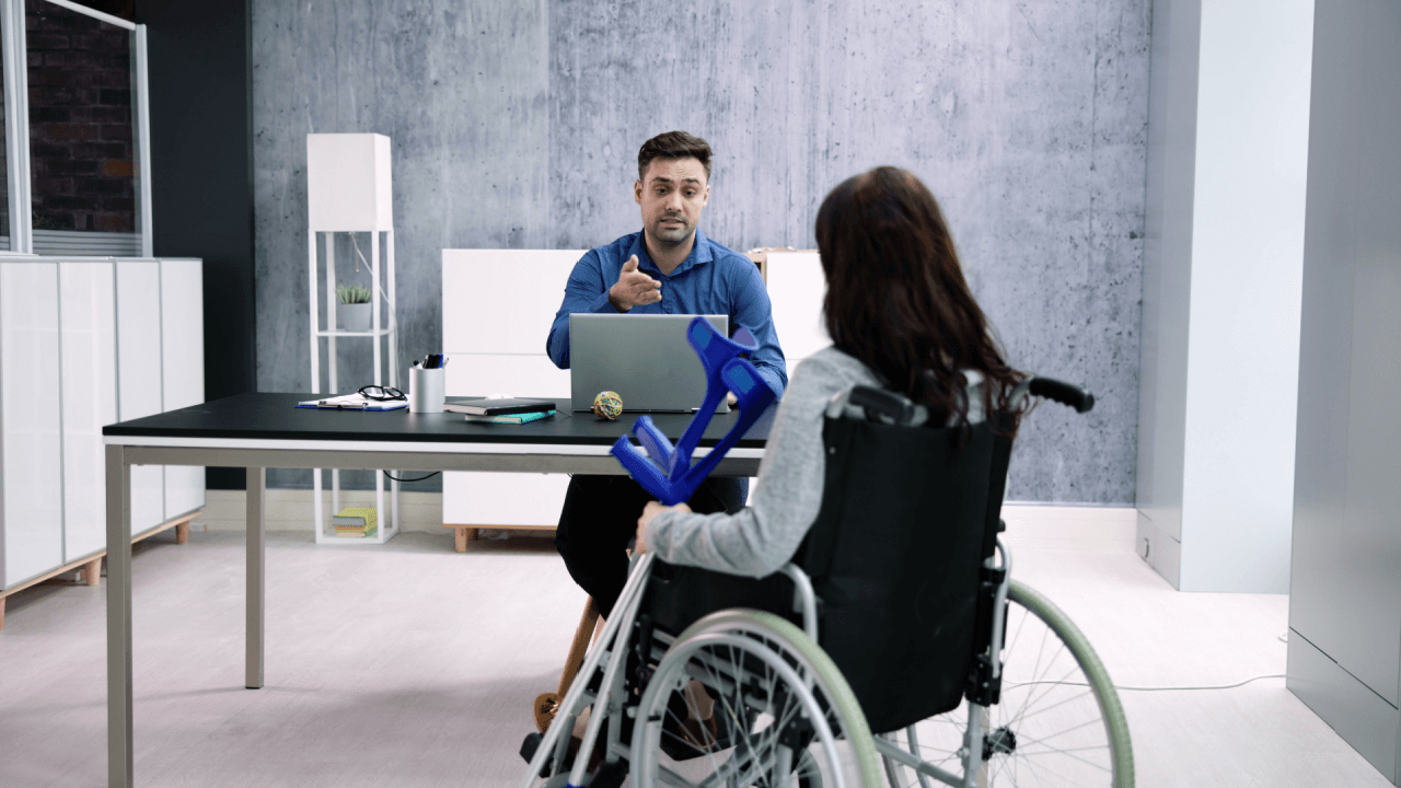 Changes in SSDI appeal outcomes discussion between disability attorney and wheelchair user reviewing case file