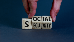 SSDI changes and updates concept with hands arranging Social Security wooden letter blocks on blue surface