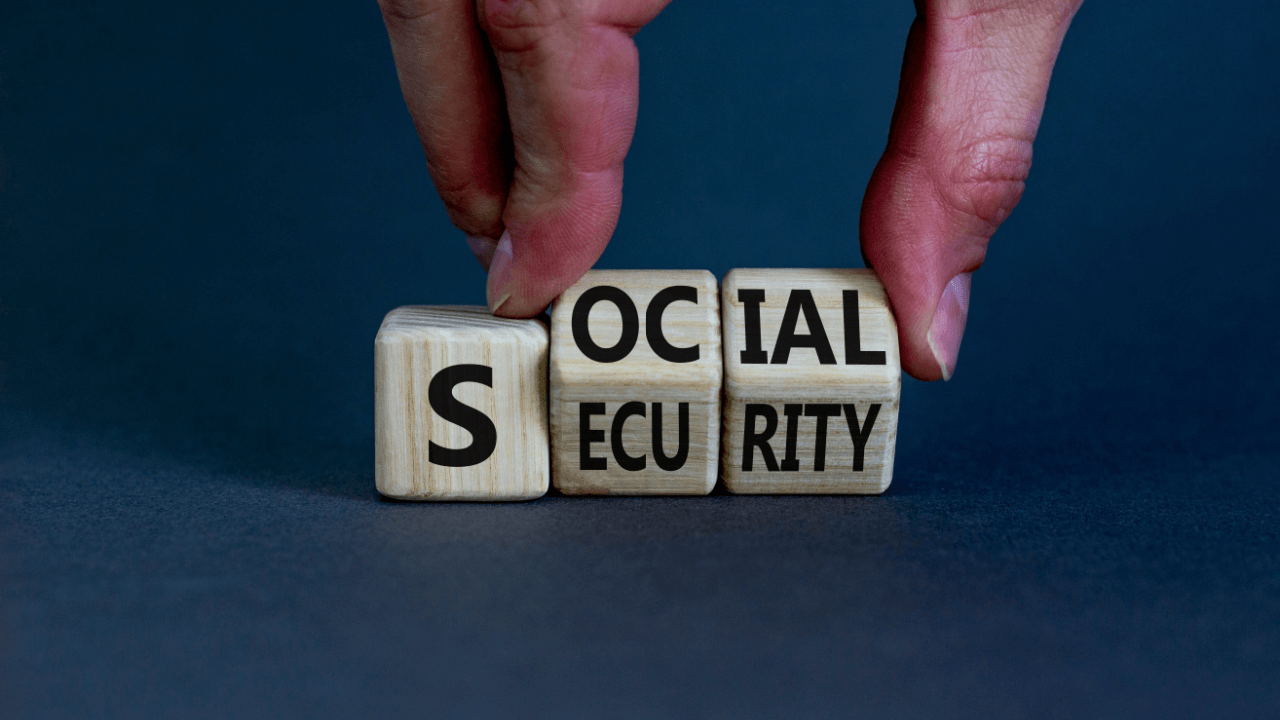 SSDI changes and updates concept with hands arranging Social Security wooden letter blocks on blue surface