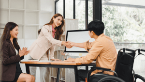 Man in wheelchair shaking hands with SSDI attorney during disability review consultation
