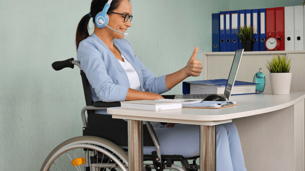 Woman in wheelchair with headset giving thumbs up while researching how long does it take to get a decision on SSDI after CDR on her laptop