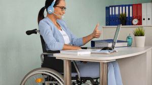 Woman in wheelchair with headset giving thumbs up while researching how long does it take to get a decision on SSDI after CDR on her laptop