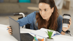 Woman in a wheelchair reviewing SSDI documents on a laptop to understand how often Social Security Disability does reviews
