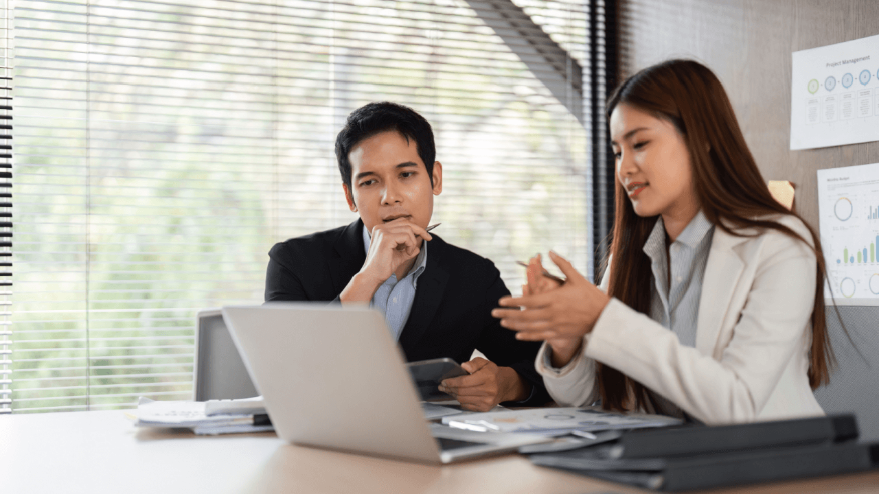 Disability attorney and client discussing SSDI continuing disability review case in office meeting