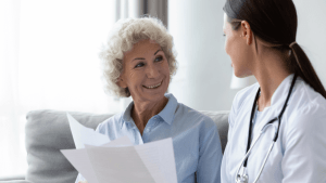 Older woman smiling while reviewing CDR documents with a medical professional to understand what are the chances of passing a CDR